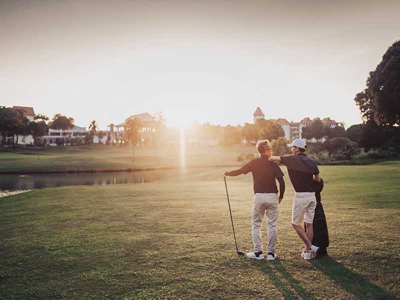 couple watching sunset in golf field